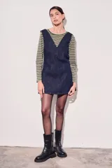 Vestido jumper corto de jean azul oscuro, con escote en V y breteles anchos.