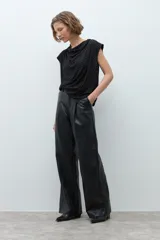 Blusa negra con pequeños puntos brillantes, cuello drapeado y mangas cortas.