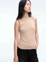 Top sin mangas al cuerpo confeccionado en tejido de viscosa con micro lentejuelas brillantes. Presenta cuello alto y diseño elástico, ideal para diversas ocasiones.