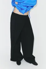 Pantalón de tiro alto con diseño cruzado tipo pareo en el frente, pernera ancha y caída fluida.
