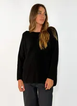 Sweater de punto negro con cuello redondo, manga larga y corte holgado.