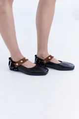 Ballerinas de cuero bordó con puntera cuadrada, diseño destalonado y tira en el empeine decorada con tachas metálicas.