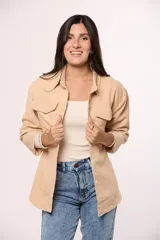 Camisa de pana fina color beige, con cuello clásico, cierre frontal de botones y dos bolsillos con solapa en el pecho.