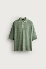 Polo de punto de algodón con textura acanalada, color verde militar, efecto lavado, cuello solapa, cierre frontal con botones y mangas cortas holgadas.