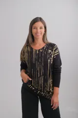 Sweater de punto negro con escote en V y mangas largas, presenta un estampado abstracto de líneas verticales y salpicaduras en color dorado.