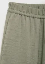 Pantalón largo de tiro alto color verde, con cintura elástica y cordón ajustable, de diseño recto y tejido con textura.