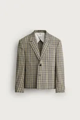 Blazer de corte boxy fit de Zara, confeccionado en tejido con algodón con estampado a cuadros en tonos beige, negro y blanco. Cuenta con cuello de solapas de muesca, manga larga con botones en los puños, bolsillos de vivo en el pecho y de plastrón en la cadera, y cierre frontal con un botón.