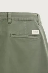 Pantalón chino skinny fit color gris oscuro, confeccionado en mezcla de algodón con elasticidad. Cuenta con bolsillos frontales, bolsillos traseros de vivo y cierre frontal con cremallera y botón.