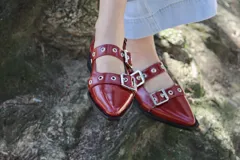 Zapatos de charol color borgoña, estilo Mary Jane, con punta fina, doble tira con hebilla plateada y ojalillos metálicos.