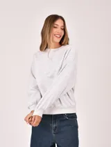 Buzo de cuello redondo en color gris melange, con diseño de corte holgado y mangas largas con puños elásticos.