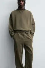 Sudadera de corte boxy fit con efecto lavado, cuello redondo con detalle de costura triangular y acabados con bordes deshilachados en el ruedo y las costuras. Presenta manga larga con puños acanalados.