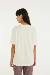 Remera Farm de algodón color blanco, con cuello redondo, mangas cortas y estampa frontal ilustrada con loros, botellas y la inscripción 'Bar Do Momo'.