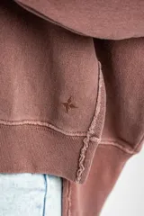 Sweater de algodón peinado con efecto lavado, de corte oversize, cuello redondo y mangas largas con costuras visibles.