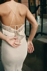 Vestido largo de georgette con escote en pico, tirantes finos cruzados en la espalda y detalle de volantes aplicados en el pecho.