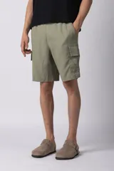 Bermuda cargo confeccionada en una mezcla de lino y rayón en color verde militar. Presenta un diseño de calce relajado con bolsillos laterales tipo cargo con solapa y cintura elástica para mayor comodidad.