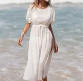 Vestido blanco de playa con mangas cortas y aberturas laterales.