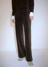 Pantalon de corte recto confeccionado en tejido de pana color marrón oscuro, con cintura elástica.