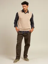 Pantalón de vestir color beige con pinzas, bolsillos laterales y traseros. El ruedo tiene un pequeño corte lateral.