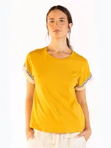 Remera color naranja de manga corta, confeccionada en algodón, con detalles de flecos y bordado en las mangas.