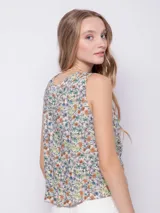 Blusa sin mangas de tela fluida con estampado floral en blanco y negro. Cuenta con jareta para fruncir en la parte delantera central.