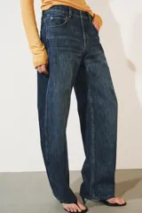 Jeans de tiro medio confeccionados en denim con efecto lavado, diseño de pernera curva y corte recto. Cuenta con cinco bolsillos, trabillas en la cintura y cierre frontal con cremallera y botón metálico.