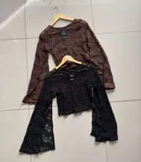 Blusa de encaje con diseño texturizado, cuello redondo y mangas largas acampanadas.