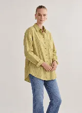 Camisa oversize de manga larga color verde lima con patrón de rayas verticales oscuras, cuello clásico, cierre frontal con botones y un bolsillo aplicado en el pecho.