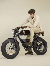 Pantalón cargo negro de sarga de algodón con spandex, con bolsillos laterales con solapa y etiqueta con el logo de la marca en uno de ellos.