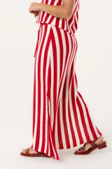 Falda larga tejida a rayas verticales rojas y blancas, con pretina elástica y tajos laterales.