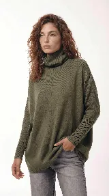 Sweater de punto color gris, con cuello polera amplio y diseño oversize de silueta fluida y caída liviana.