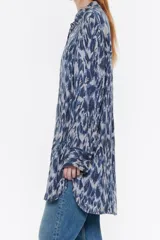 Camisa larga de viscosa con estampado de cebra en blanco y negro. Modelo de corte recto, cuello camisero, manga larga, puño con botones y cierre frontal de botonadura.