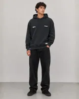 Canguro con capucha de color negro con efecto lavado, manga larga y bolsillo frontal tipo canguro. Presenta un pequeño estampado gráfico en el pecho con el logo de la marca.