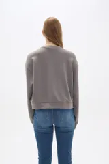 Buzo gris de corte ancho y cuello redondo.