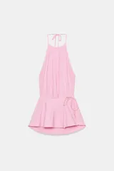 Top halter de mezcla de algodón en color rosado, con cuello halter ajustable mediante lazada, espalda descubierta y detalle de fajín cruzado con lazo en la cintura.