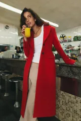 Abrigo largo de Zara confeccionado en mezcla de lana color rojo, con cuello de solapa, manga larga, bolsillos con solapa en el frente y cierre frontal de botones negros.