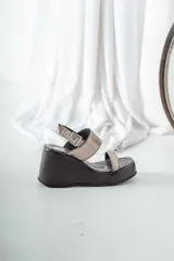 Sandalias de cuero color negro con plataforma y dos tiras horizontales plateadas.