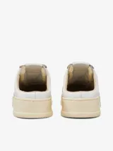 Zapatilla Autry Medalist Mule Low de cuero blanco con cordones y suela color crema.