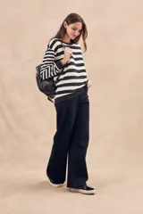 Sweater de punto a rayas horizontales anchas en color negro y crudo, de corte oversize, mangas largas y cuello redondo.