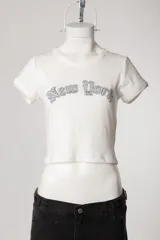 Remera de morley de manga corta, color gris, ajustada al cuerpo y elastizada, con bordado estilo college con la inscripción 'New York' en el pecho.
