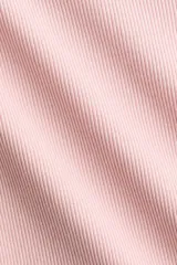 Remera básica de corte entallado y mangas cortas, confeccionada en tejido de punto acanalado de algodón color rosado, con cuello redondo fino y bajo recto.