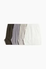 Pack de cuatro calzoncillos tipo bóxer de algodón suave, con cintura elástica y bragueta con botones. Incluye colores marrón, gris, beige y blanco.