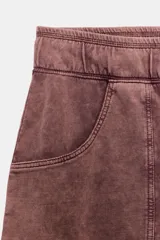 Bermuda larga de algodón con efecto lavado, color bordó, tiro medio y cintura elástica ajustable con cordón. Cuenta con bolsillos de plastrón en el delantero y bajo ajustable con cordones.