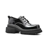 Zapato acordonado de cuero marrón con costuras blancas y plataforma track.