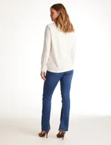 Remera de modal con cuello solapa, escote en V y cierre frontal con botones. Presenta mangas largas con puños elásticos y un corte recto con dobladillo ligeramente más largo en la parte posterior.