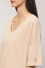 Remera oversize color blanco, confeccionada en jersey Pima flamé de algodón. Cuenta con escote en V, mangas cortas con detalle de bordado en la manga y cintura con elástico que genera un efecto balloon.