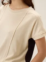 Remera negra de punto fino, con mangas cortas, cuello redondo y corte relajado. Cuenta con costuras verticales decorativas en el frente.