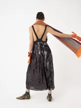 Vestido largo negro con lentejuelas y detalles de encaje, con tirantes finos y escote en V.