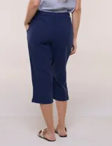 Pantalón capri de algodón a rayas verticales en tonos azul, celeste y blanco, con cintura elastizada, cordón de ajuste frontal y bolsillos aplicados.