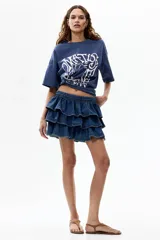 Remera oversized de algodón color azul, con hombros caídos, cuello redondo y estampa gráfica frontal de estilo artístico en tono claro.