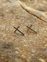 Par de aros pequeños con forma de cruz, color dorado.